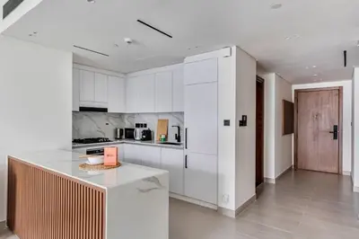 a kitchen with white cabinets and a counter top at GuestReady – Modern comfort in JVC in Dubai