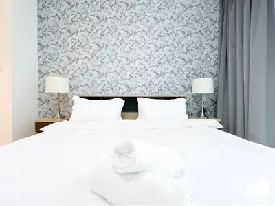 a bedroom with a white bed with two lamps at Spacious 2B in Sobha Creek Vistas ,Dubai in Dubai
