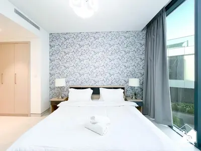 a bedroom with a large white bed with two lamps at Spacious 2B in Sobha Creek Vistas ,Dubai in Dubai