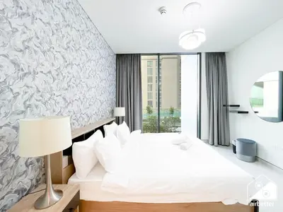 a bedroom with a white bed and a window at Spacious 2B in Sobha Creek Vistas ,Dubai in Dubai