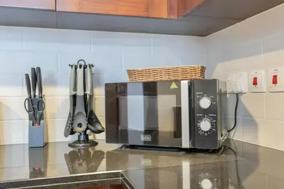 a microwave on a counter in a kitchen at 29 Boulevard by EMAAR 1BR 4min Walk to the Burj and Dubai Mall in Dubai