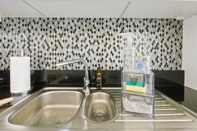 a kitchen sink with a bottle of soap and a detergent at Sky High 1BR in City View with 41st Floor Views in Dubai