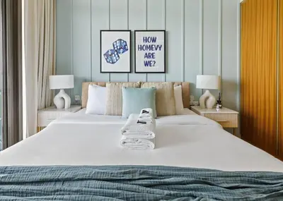 a bedroom with a large white bed with two lamps at Sky High 1BR in City View with 41st Floor Views in Dubai