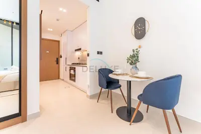 a dining room with a table and two chairs at Studio Near Dubai Autodrome & Trump Golf Club, Binghatti Amber, JVC By Deluxe Holiday Homes in Dubai