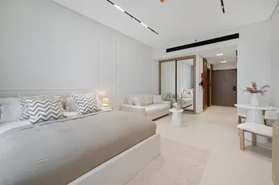 a white bedroom with a bed and a living room at Daniels Studio with Canal View at Marasi Drive in Dubai
