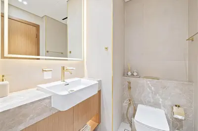 a bathroom with a sink and a toilet and a mirror at Daniels Studio with Canal View at Marasi Drive in Dubai