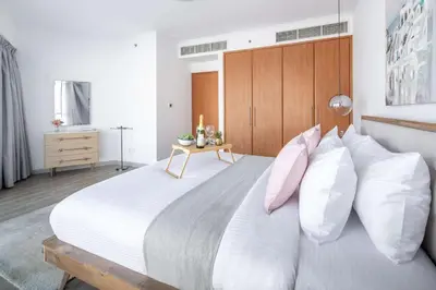 a bedroom with a large white bed with pink pillows at Frank Porter - Saba 3 in Dubai