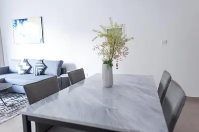 a dining room with a table with a vase on it at Park Heights 2 Dubai Hills 1BR by Happy Season in Dubai