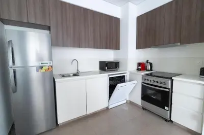 a kitchen with white cabinets and a stainless steel refrigerator at Park Heights 2 Dubai Hills 1BR by Happy Season in Dubai