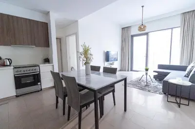 a kitchen and living room with a table and chairs at Park Heights 2 Dubai Hills 1BR by Happy Season in Dubai