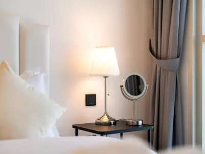 a lamp on a table next to a bed at Luxury 1-BR Escape in Dubai Hills Collective , 5 min from Mall in Dubai