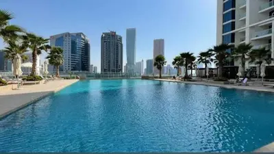 a large swimming pool in a city with tall buildings at Dubai Dreams Pool & Canal View at Prive in Dubai