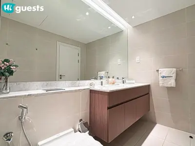 a bathroom with a sink and a mirror and a toilet at HiGuests - La Rive Living Classy 2BR with Balcony in Dubai