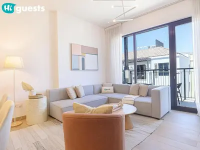 a living room with a couch and a table at HiGuests - La Rive Living Classy 2BR with Balcony in Dubai
