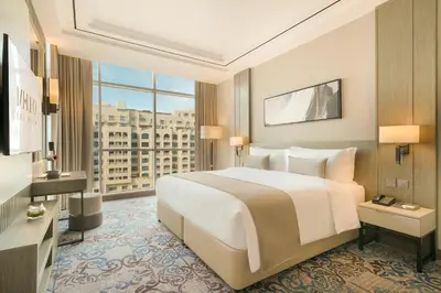a bedroom with a large white bed and a large window at Mileo Hotel The Palm in Dubai