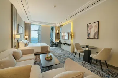 a hotel room with a king bed and a living room at Mileo Hotel The Palm in Dubai