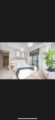 a bedroom with a large bed and a potted plant at Modern 2 BDR Apartment in Business Bay, Ocean & Burj AlArab Stunning View in Dubai
