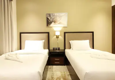 two beds in a hotel room with white sheets at Downtown Dubai Stay in 2BR Chic Elite Apartment in Dubai
