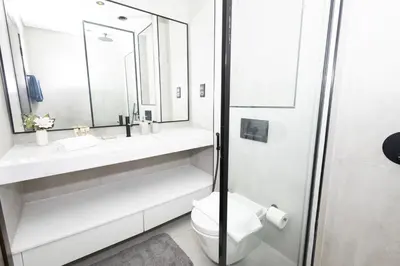 a bathroom with a toilet and a sink and a mirror at Spacious 2BR Apartment l Rooftop Pool l Gym in Dubai