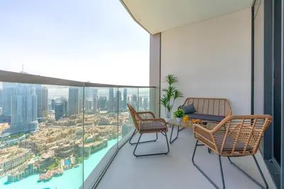 a balcony with chairs and a table on a building at Luxury 4BR Full Burj khalifa & Fountain View, 1Gbps, PS5 in Dubai
