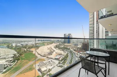 a balcony with a table and chairs and a view of a city at Modern 1BR at Golf Vita A in Damac Hills Near Golf in Dubai