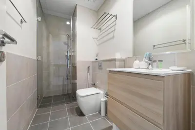 a bathroom with a shower and a toilet and a sink at Modern 1BR at Golf Vita A in Damac Hills Near Golf in Dubai