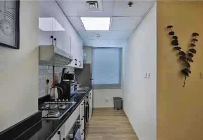 a kitchen with white walls and a long hallway at Near Metro Station - 1BR in Marina Diamond 3, Dubai Marina - Allsopp & Allsopp in Dubai