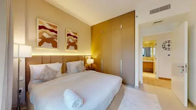 a bedroom with a large white bed and a bathroom at FAM Living - Modern 1BR at Orchid, Creek Harbour in Dubai