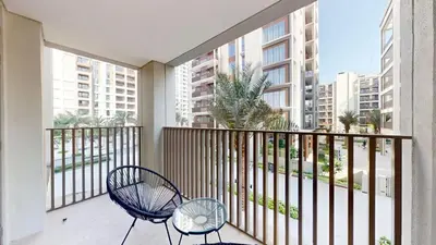 a balcony with a chair and a table and some buildings at FAM Living - Modern 1BR at Orchid, Creek Harbour in Dubai