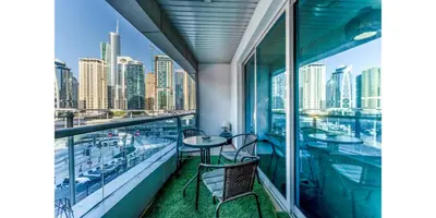 a balcony with two tables and chairs and a city skyline at 8min Walk from JBR beach Stylish 1-Bedroom Apartment in Dubai Marina in Dubai