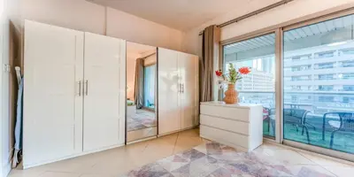 a room with white cabinets and a large window at 8min Walk from JBR beach Stylish 1-Bedroom Apartment in Dubai Marina in Dubai