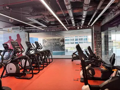 a gym with rows of exercise bikes and treadmills at Stylish 2BR in Royal MBL in Dubai
