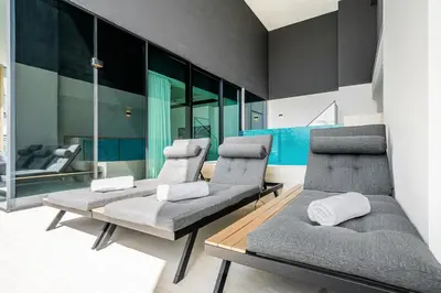 a room with three chairs and a couch at Vibrant - 2BR - Exclusive Pool, Shared Gym in Dubai