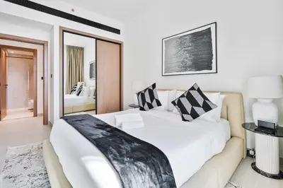 a bedroom with a large white bed with a couch at Vibrant - 2BR - Exclusive Pool, Shared Gym in Dubai