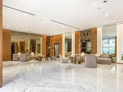 a lobby with couches and chairs in a building at Vibrant - 2BR - Exclusive Pool, Shared Gym in Dubai
