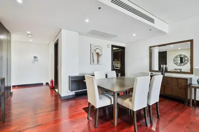 a dining room with a wooden table and white chairs at Spacious 2 Bed Unit With Aquaventure Waterpark Views in Dubai