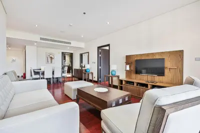 a living room with white furniture and a flat screen tv at Spacious 2 Bed Unit With Aquaventure Waterpark Views in Dubai