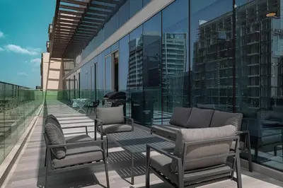 a balcony with chairs and a couch on a building at Stylish 1BR with Spacious Terrace Near Circle Mall in Dubai