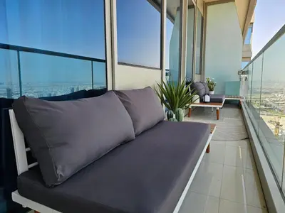a couch sitting in a room with windows at New Renovated Stylish 1 Br Dubai View 73 Floor in Dubai