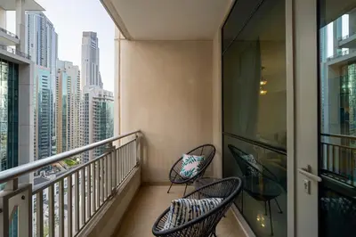 two chairs on a balcony with a view of a city at Spacious 2 bedroom apartment in Downtown Dubai in Dubai