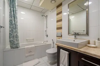 a bathroom with a sink and a toilet and a mirror at Spacious 2 bedroom apartment in Downtown Dubai in Dubai