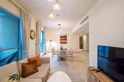 a living room with a couch and a tv and a table at Spacious 2 bedroom apartment in Downtown Dubai in Dubai
