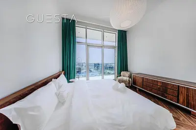 a bedroom with a large bed with a window at Emaar Beachfront - Sunrise Bay Tower 1, Dubai Marina in Dubai