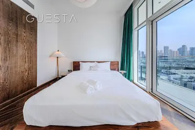a bedroom with a large white bed and a large window at Emaar Beachfront - Sunrise Bay Tower 1, Dubai Marina in Dubai