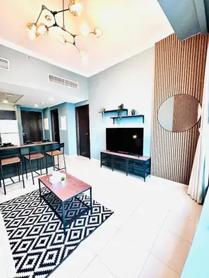 a living room with a television and a table at Bright and Modern Condo in Dubai Marina in Dubai