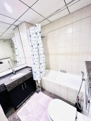 a bathroom with a tub and a toilet and a sink at Bright and Modern Condo in Dubai Marina in Dubai