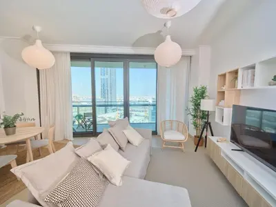 a living room with a couch and a television at Luxury 1BR Downtown Dubai Skyline & Sea View in Dubai