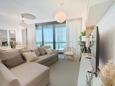 a living room with a couch and a table at Luxury 1BR Downtown Dubai Skyline & Sea View in Dubai