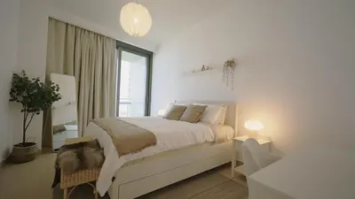 a white bedroom with a bed and a window at Luxury 1BR Downtown Dubai Skyline & Sea View in Dubai
