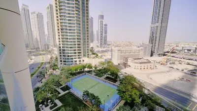 an aerial view of a city with a tennis court at Luxury 1BR Downtown Dubai Skyline & Sea View in Dubai